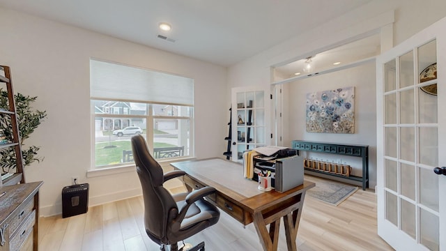 office space with visible vents, baseboards, and light wood-style floors