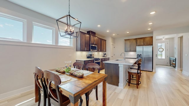 dining space with recessed lighting, baseboards, light wood-style floors, and a chandelier