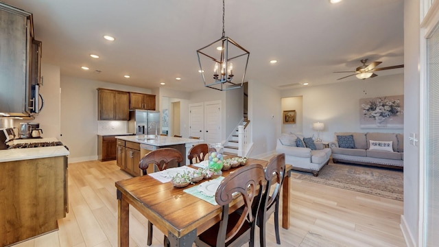 dining room with recessed lighting, stairway, light wood-style flooring, and ceiling fan with notable chandelier