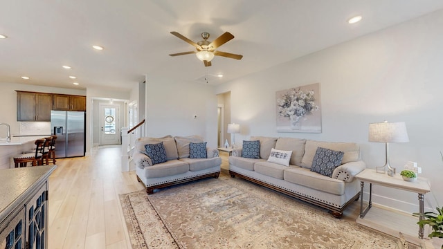 living area with recessed lighting, light wood-type flooring, baseboards, and a ceiling fan