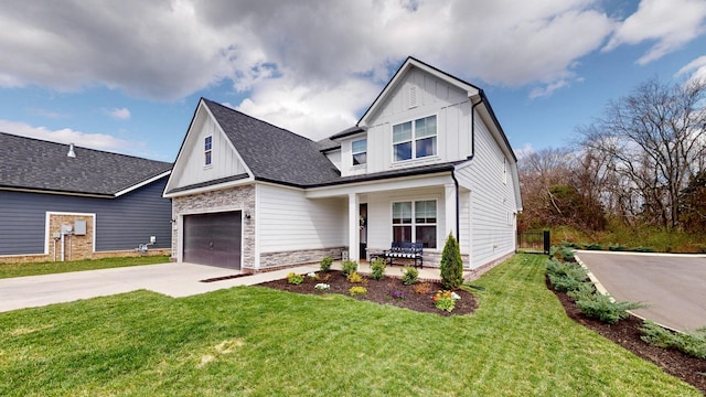 view of front of property with stone siding, covered porch, board and batten siding, concrete driveway, and a front yard