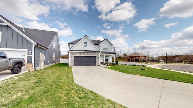 modern inspired farmhouse with stone siding, driveway, board and batten siding, and a front yard