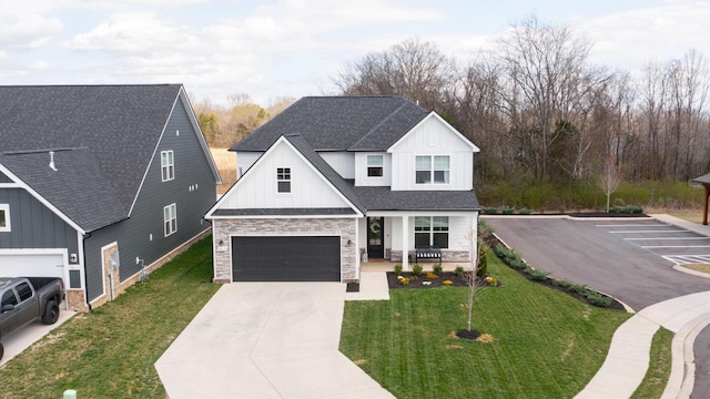 modern farmhouse style home featuring roof with shingles, covered porch, a front lawn, stone siding, and board and batten siding