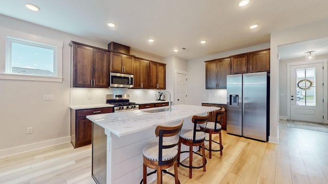 kitchen with tasteful backsplash, appliances with stainless steel finishes, a wealth of natural light, and a sink