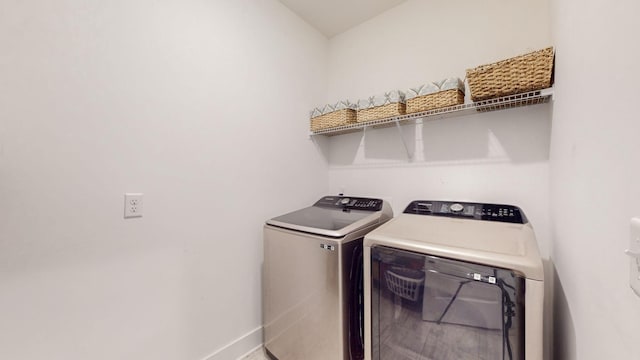 laundry area featuring baseboards, independent washer and dryer, and laundry area