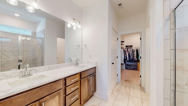 full bathroom featuring a sink, a walk in closet, a stall shower, and double vanity