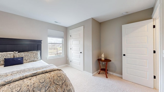 bedroom with visible vents, light colored carpet, and baseboards