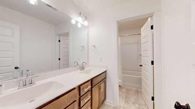 bathroom featuring double vanity, visible vents, toilet, and a sink