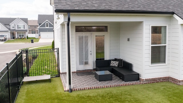 property entrance featuring fence, roof with shingles, an outdoor hangout area, a yard, and a patio