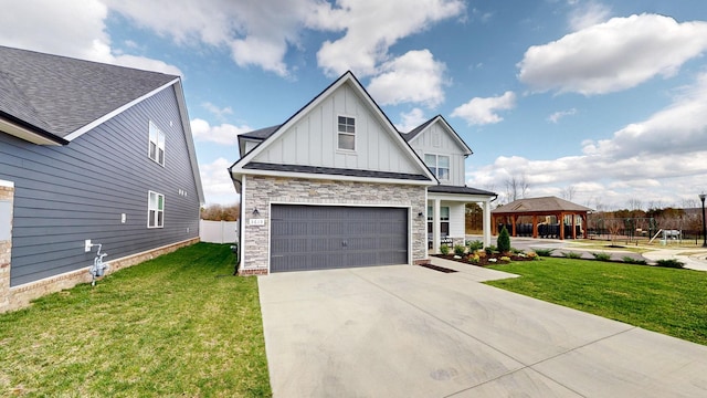 view of front facade featuring a gazebo, concrete driveway, board and batten siding, and a front lawn