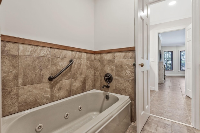 bathroom with tile walls, a jetted tub, and tile patterned flooring