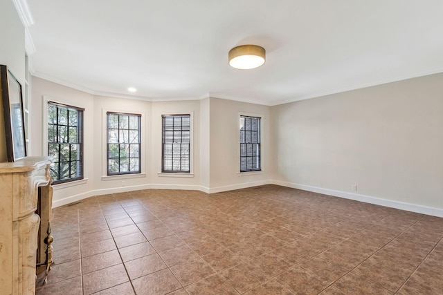 tiled empty room with baseboards and ornamental molding