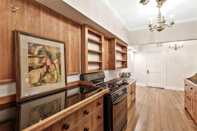 kitchen featuring brown cabinets, light wood-style flooring, ornamental molding, black gas stove, and a chandelier