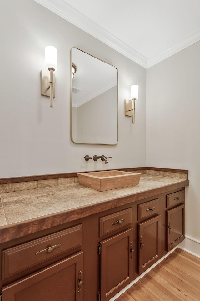 bathroom with vanity, wood finished floors, and crown molding