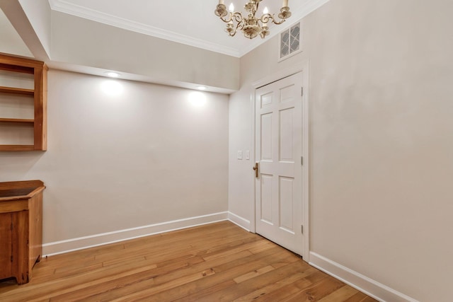 interior space with visible vents, light wood-style flooring, an inviting chandelier, crown molding, and baseboards