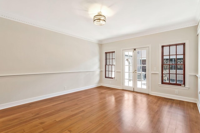 unfurnished room featuring baseboards, wood finished floors, and ornamental molding