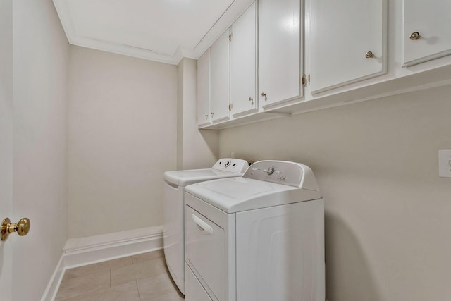 laundry room featuring crown molding, baseboards, washer and clothes dryer, light tile patterned flooring, and cabinet space