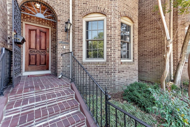 doorway to property featuring brick siding