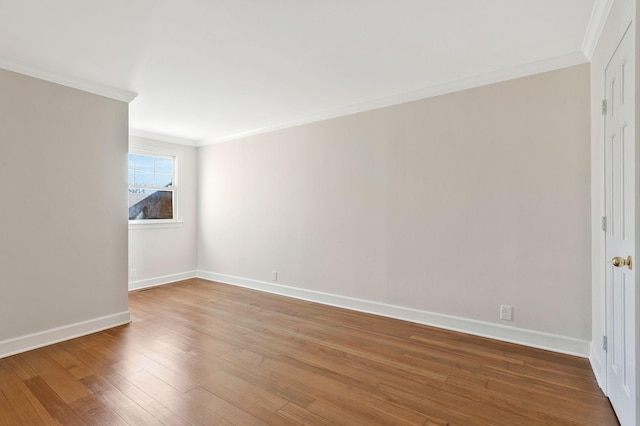 unfurnished room with wood finished floors, baseboards, and ornamental molding