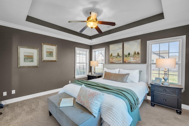 bedroom with light colored carpet, baseboards, and a tray ceiling