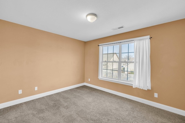 unfurnished room featuring visible vents, baseboards, and carpet