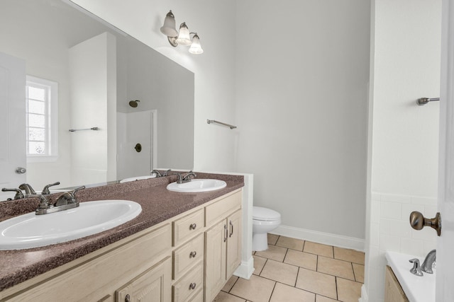 bathroom featuring tile patterned flooring, double vanity, toilet, and a sink