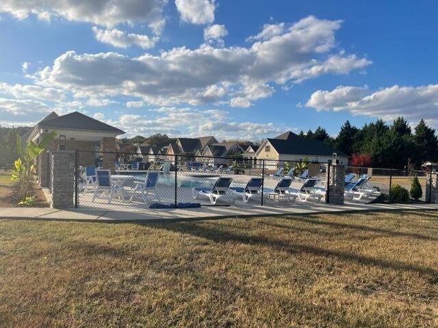 pool with fence and a lawn