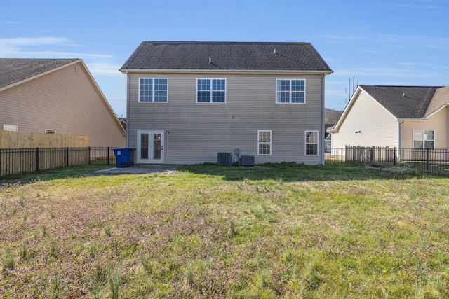 back of property featuring french doors, a lawn, and a fenced backyard