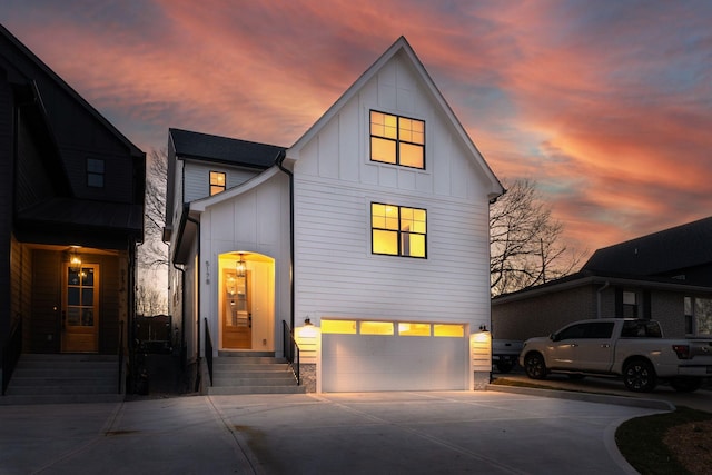 view of front of property featuring entry steps, board and batten siding, concrete driveway, and a garage