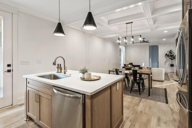 kitchen featuring open floor plan, light wood-type flooring, coffered ceiling, stainless steel appliances, and a sink