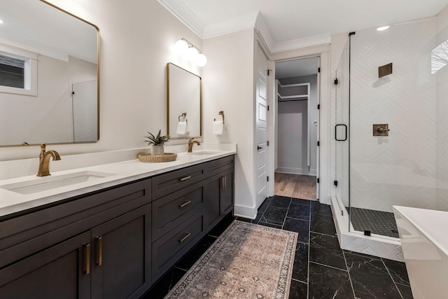 full bath featuring a sink, double vanity, a shower stall, and crown molding