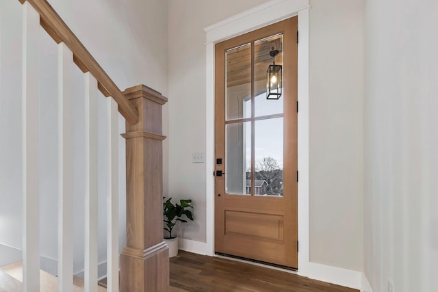 foyer entrance with stairway, baseboards, and dark wood-style flooring