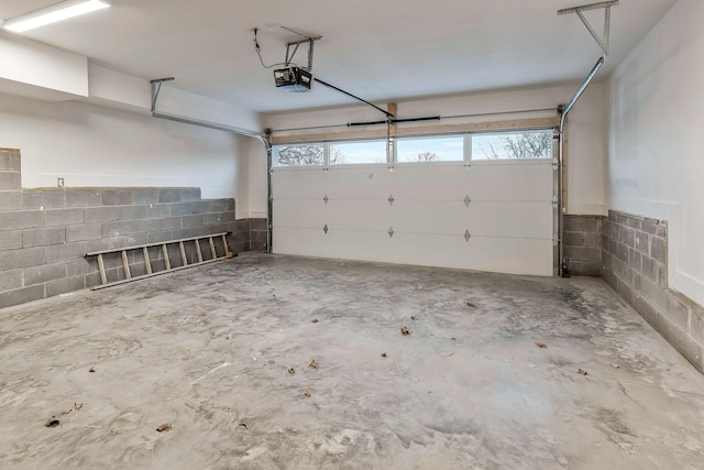 garage with concrete block wall and a garage door opener