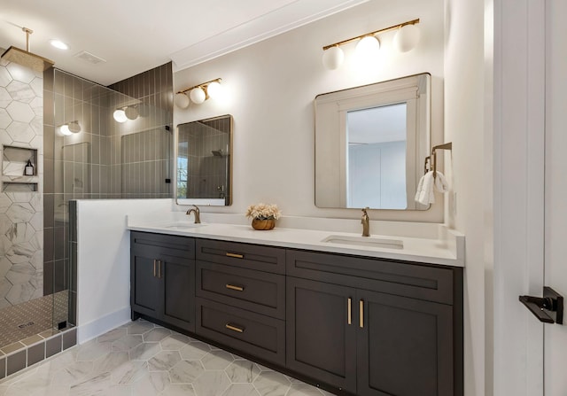 bathroom with a tile shower, visible vents, double vanity, and a sink