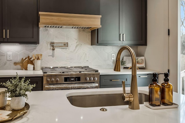 kitchen featuring decorative backsplash, gas range, custom range hood, and light countertops