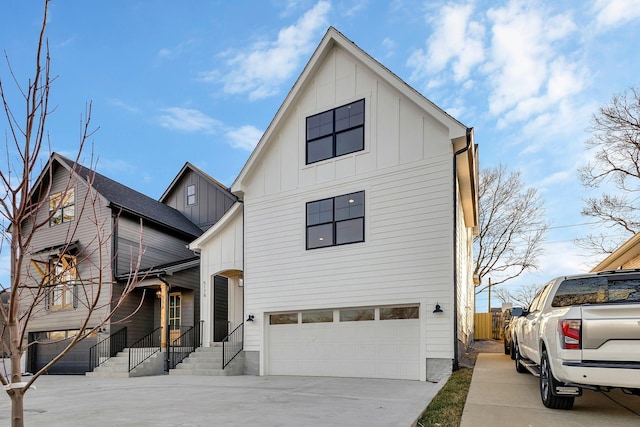 modern farmhouse style home with an attached garage, board and batten siding, driveway, and fence