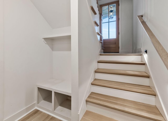 stairway with baseboards and wood finished floors