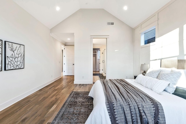 bedroom featuring baseboards, wood finished floors, visible vents, and high vaulted ceiling