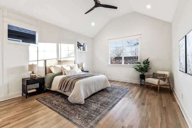 bedroom with baseboards, lofted ceiling, light wood-style flooring, and a ceiling fan