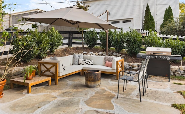 view of patio / terrace featuring grilling area, an outdoor living space, and fence