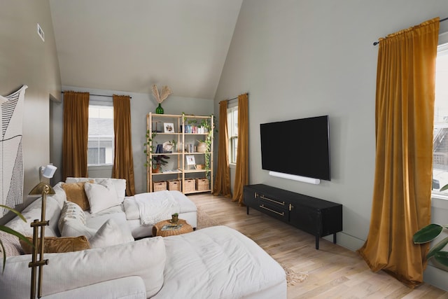 living area with high vaulted ceiling and wood finished floors