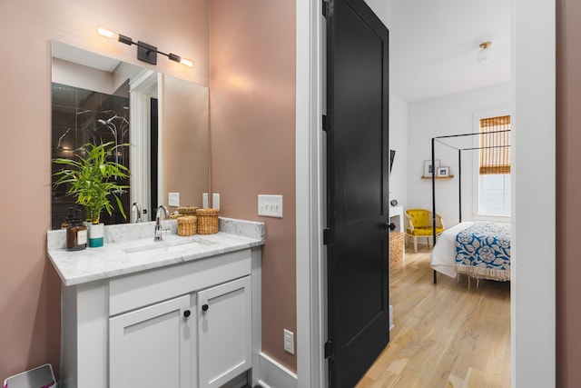 bathroom with connected bathroom, wood finished floors, and vanity