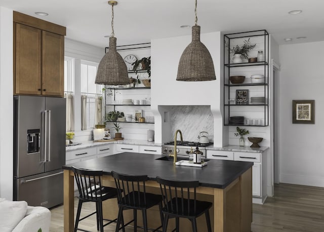 kitchen featuring open shelves, a kitchen breakfast bar, backsplash, stainless steel appliances, and light wood-style floors