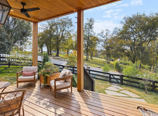 wooden terrace featuring a ceiling fan and fence