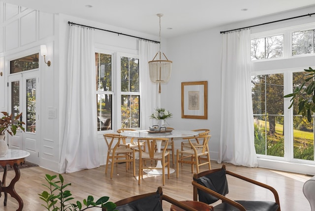 dining room with a wealth of natural light and light wood-style flooring