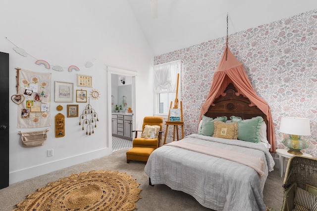 bedroom with ensuite bath, high vaulted ceiling, baseboards, and carpet