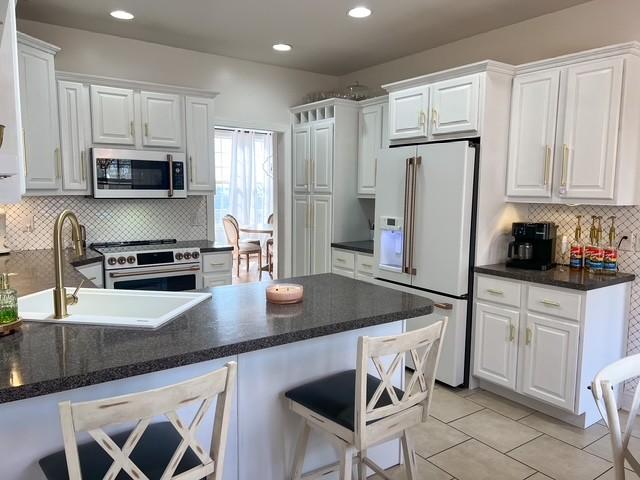 kitchen with white cabinets, high end appliances, and a sink