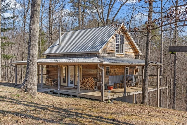 rear view of house with covered porch and metal roof