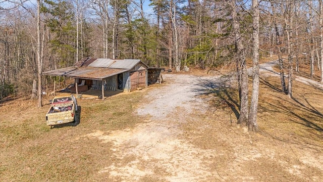 exterior space featuring an outbuilding and a forest view