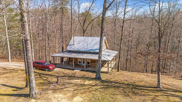 view of yard featuring a porch and a forest view